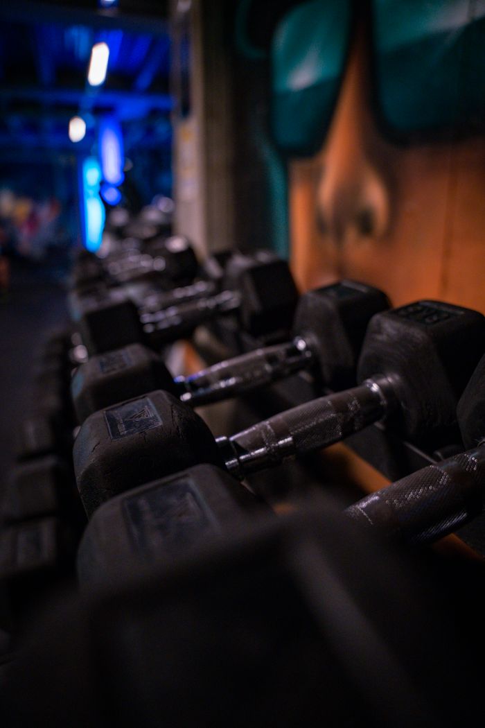 A row of black dumbbells in a gym with a modern and creative atmosphere.